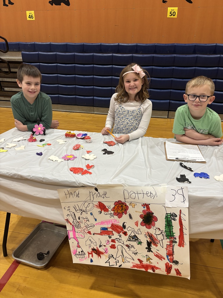 A boy and a girl stand behind a table.