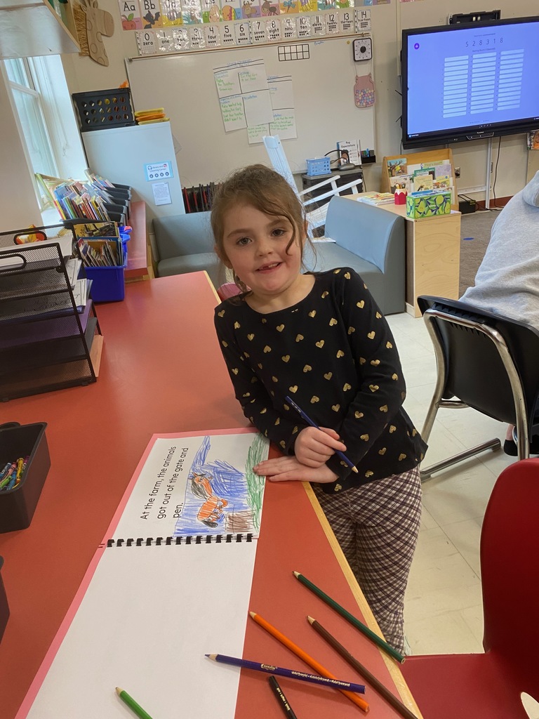 A girl stand by her work.