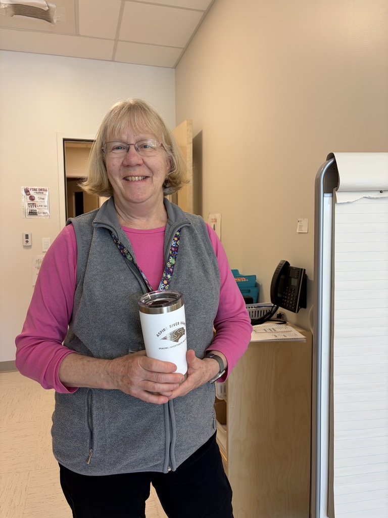 teacher holding cup in classroom