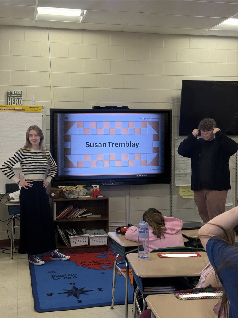 two students presenting a slideshow in front of classroom