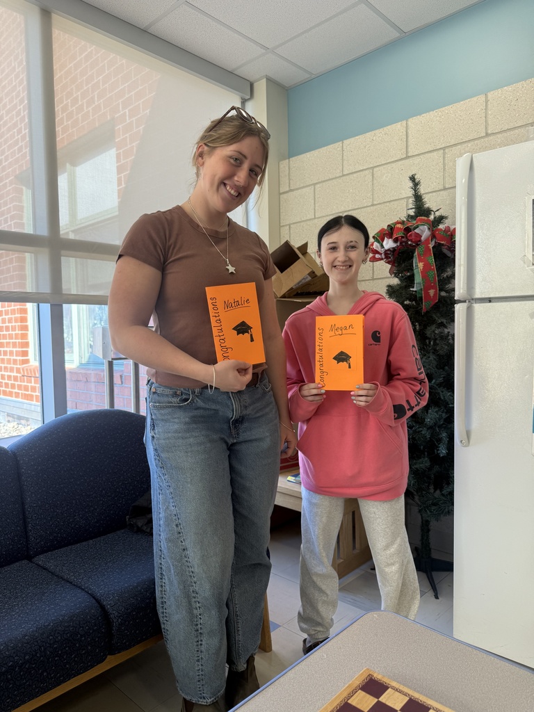two students with congratulations cards in classroom