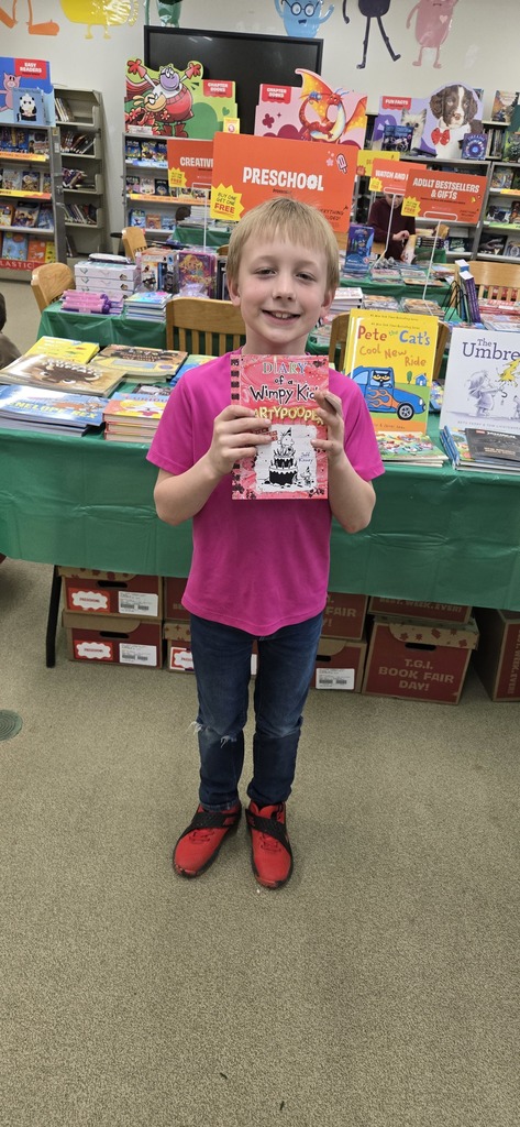 Boy holding up a book.