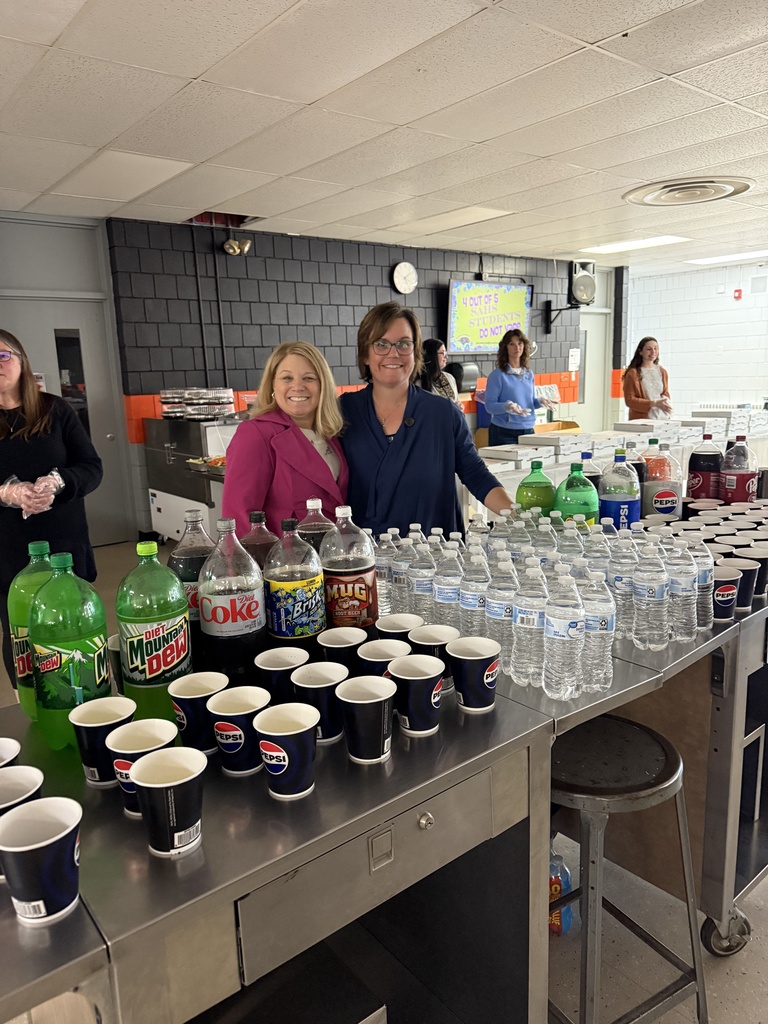 Administrators smiling for picture behind drinks table