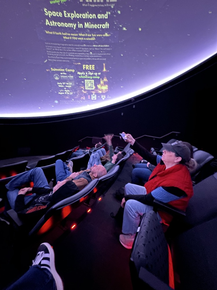 students and staff seated in the planetarium