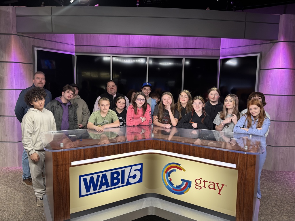 students, teacher and meteorologist standing behind WABI 5 news desk