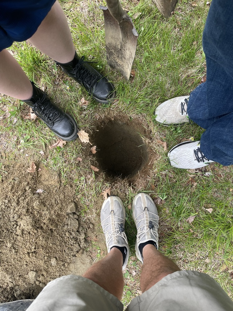 students feet next to the hole for a sign