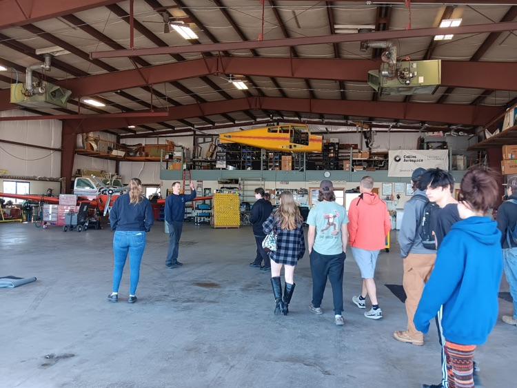 students getting a tour of the plane hanger at Augusta airport
