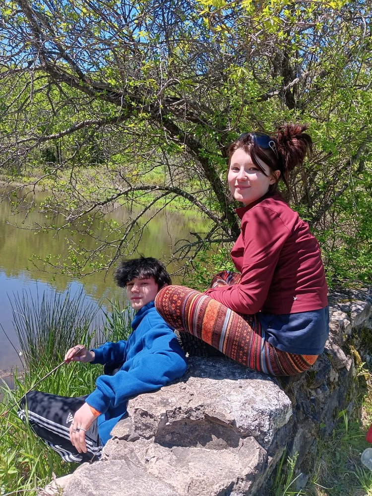 two students sitting by a pond at Viles Arboretum
