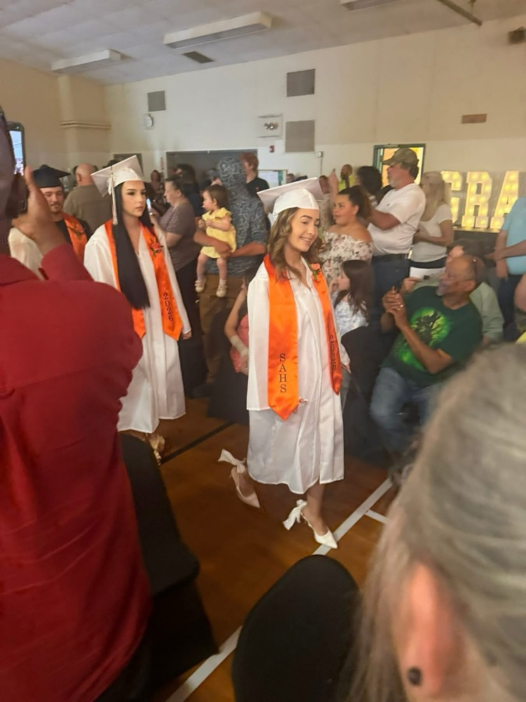 students marching into a very full gym for graduation 