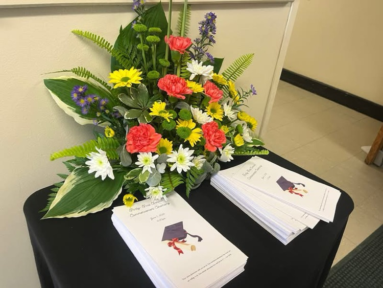 flowers on table next to graduation program