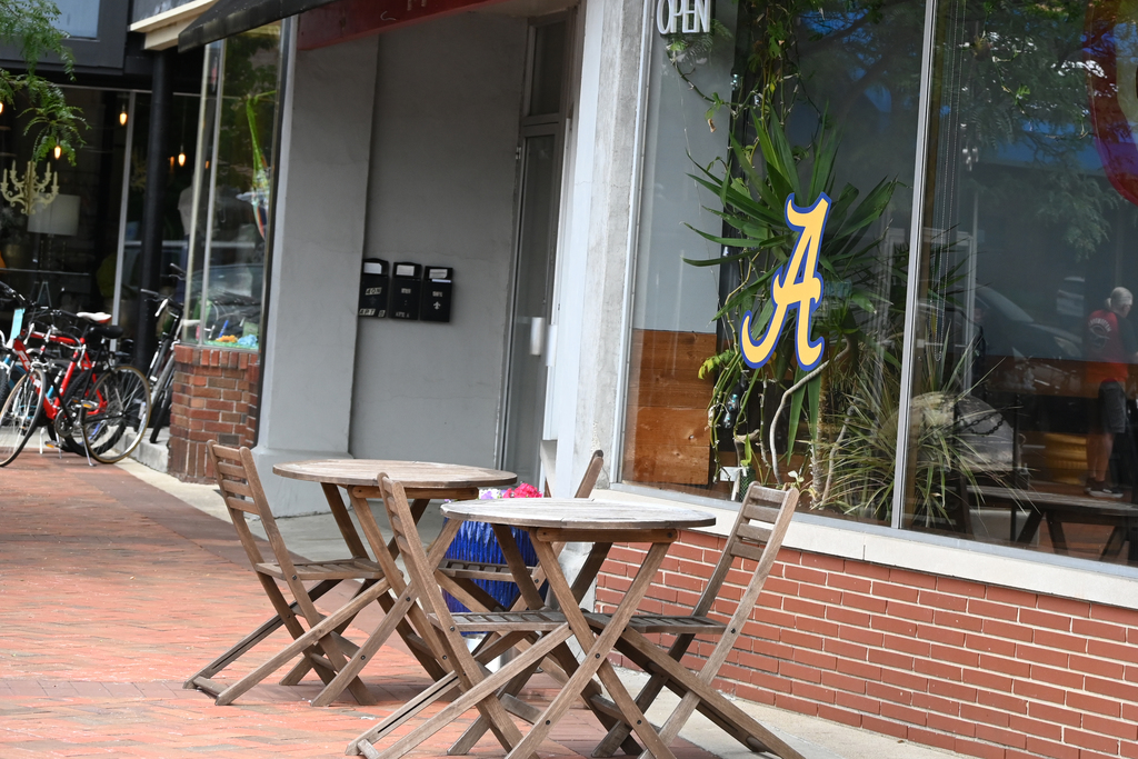 sidewalk store front with tables in front 