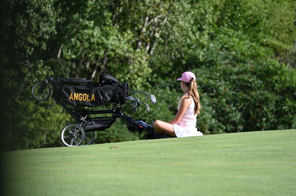 girls sitting with golf clubs