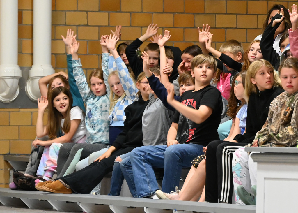 children smiling raising hands