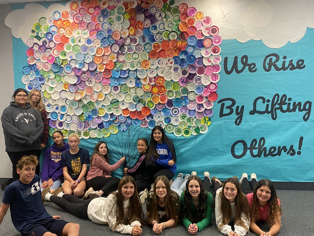 students posing in front of balloon mural