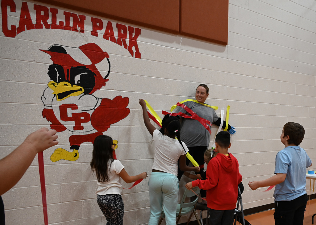 adult being duct taped to wall by students