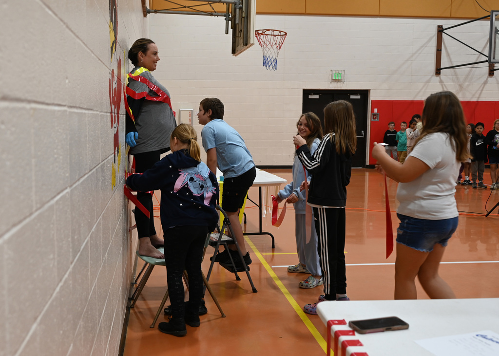 adult being duct taped to wall by students