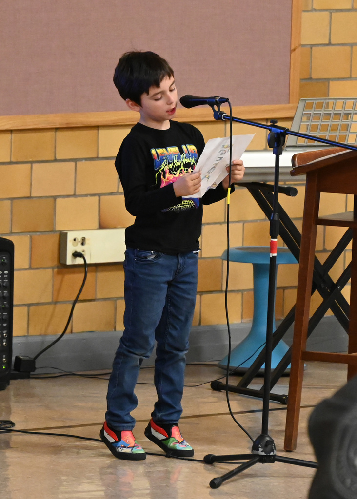boy reading in front of microphone