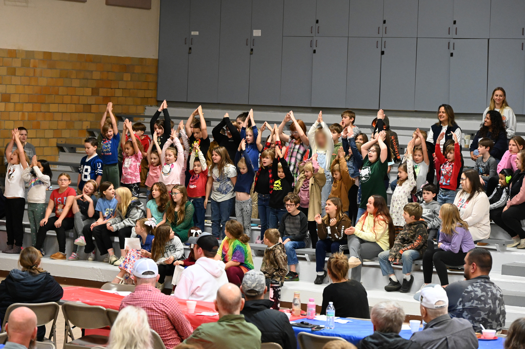 students stankding singing in a gym