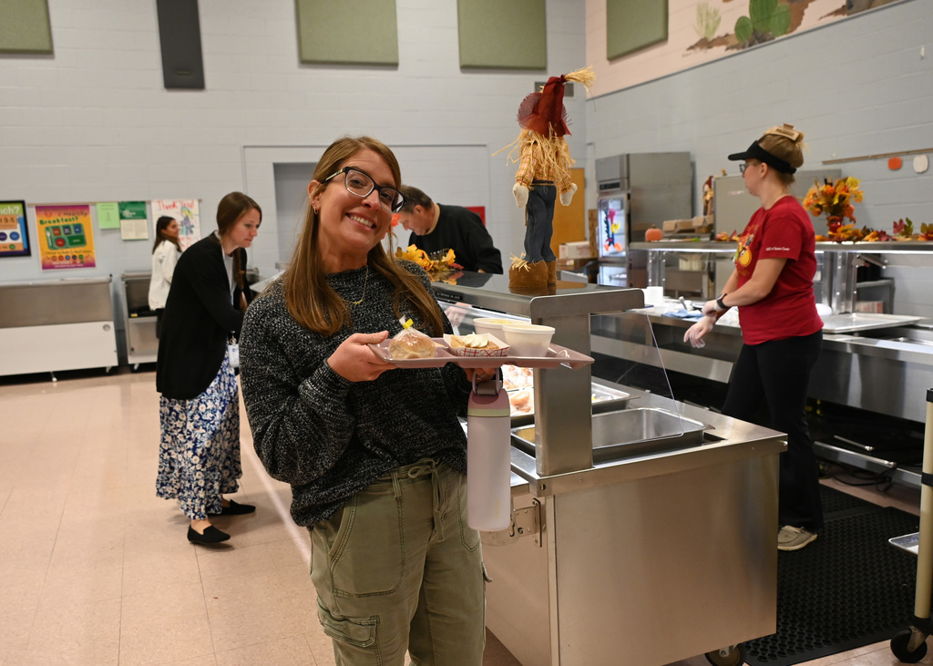 person holding tray in cafeteria