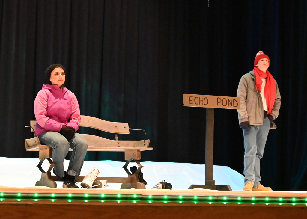 person sitting on bench another standing by a sign that says echo pond