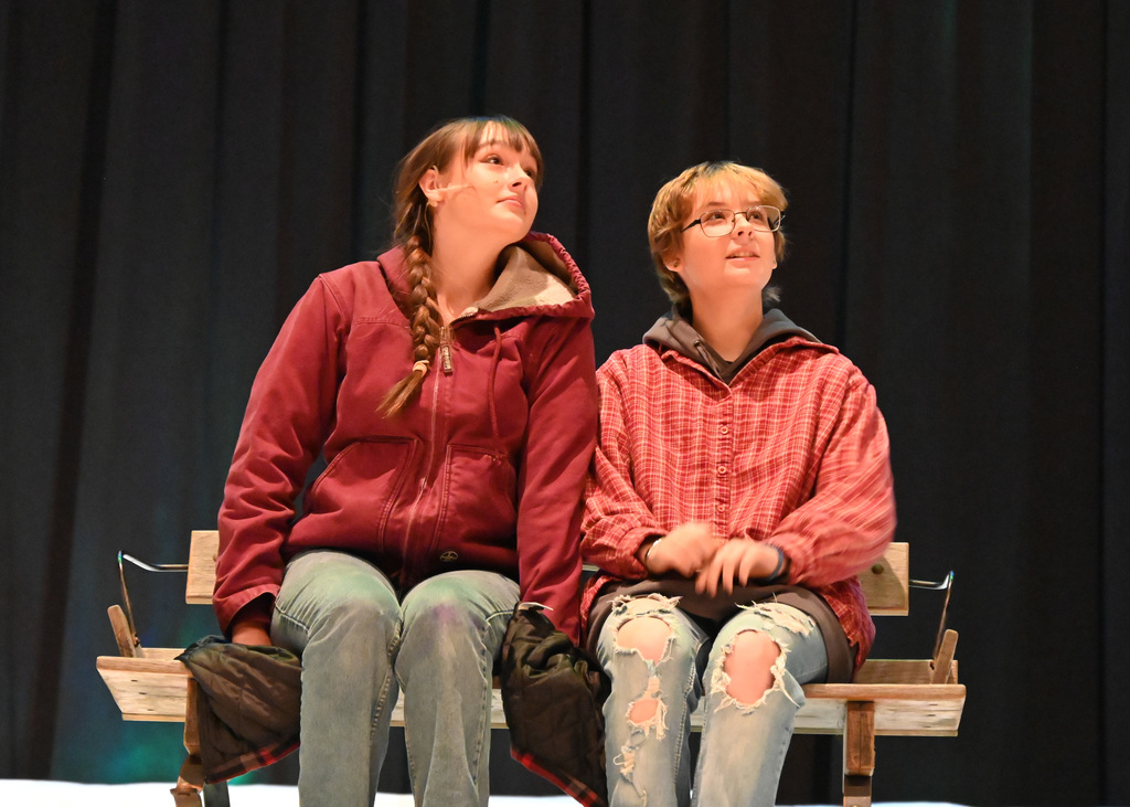 two people sitting on bench looking up