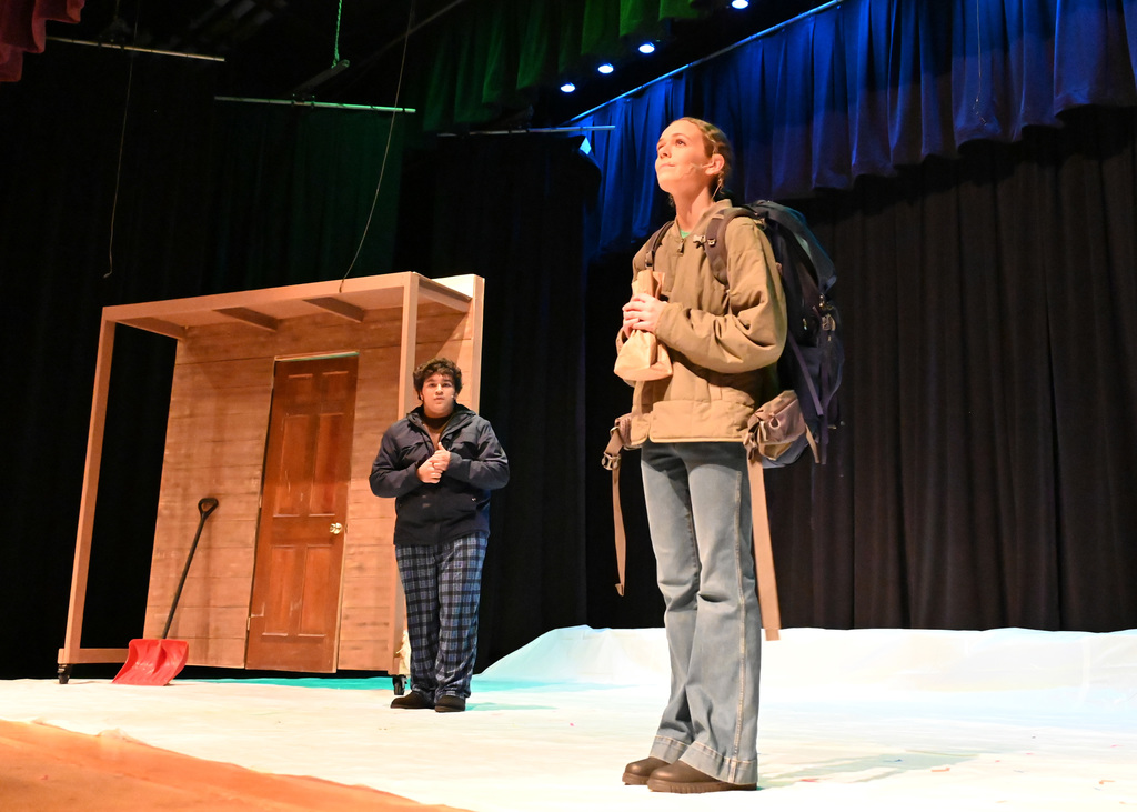 girl standing looking up being approached by someone