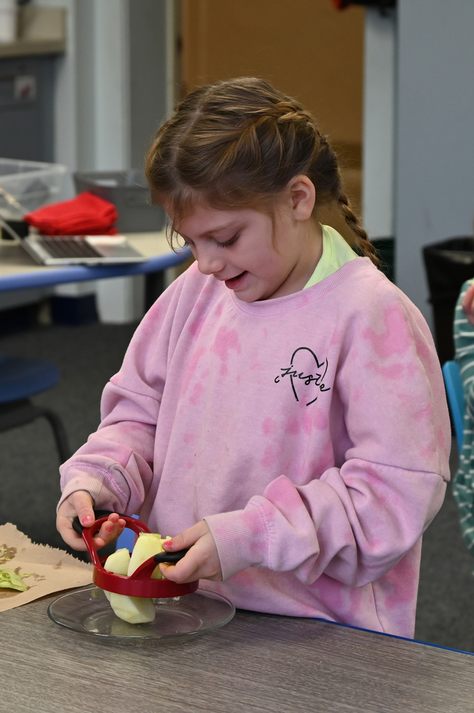 child using apple corer on an apple