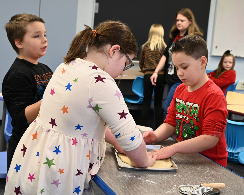 Three students making pie crust