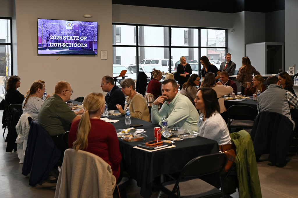 people sitting at tables talking and eating
