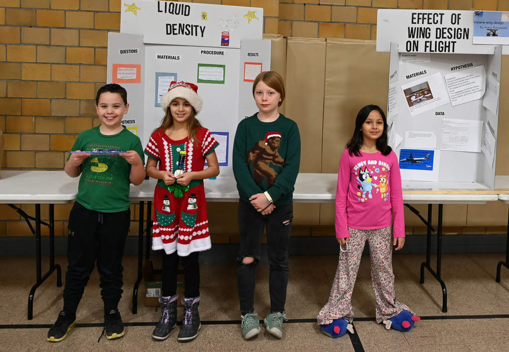 kids in a row in front of science fair project