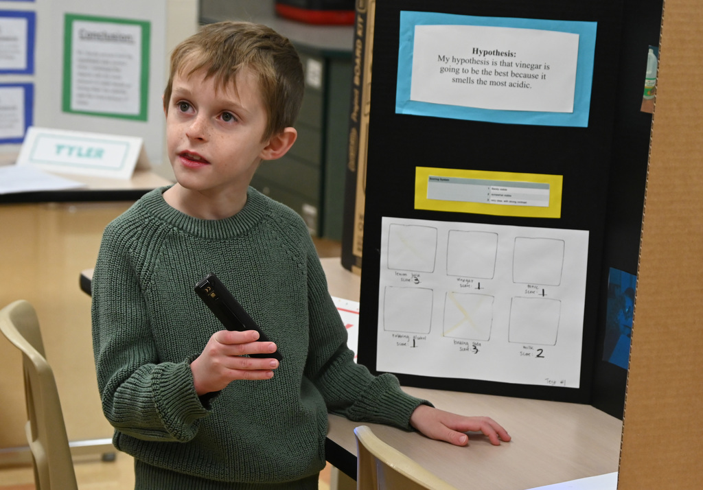 stunt with a flashligh in fron to science fair board