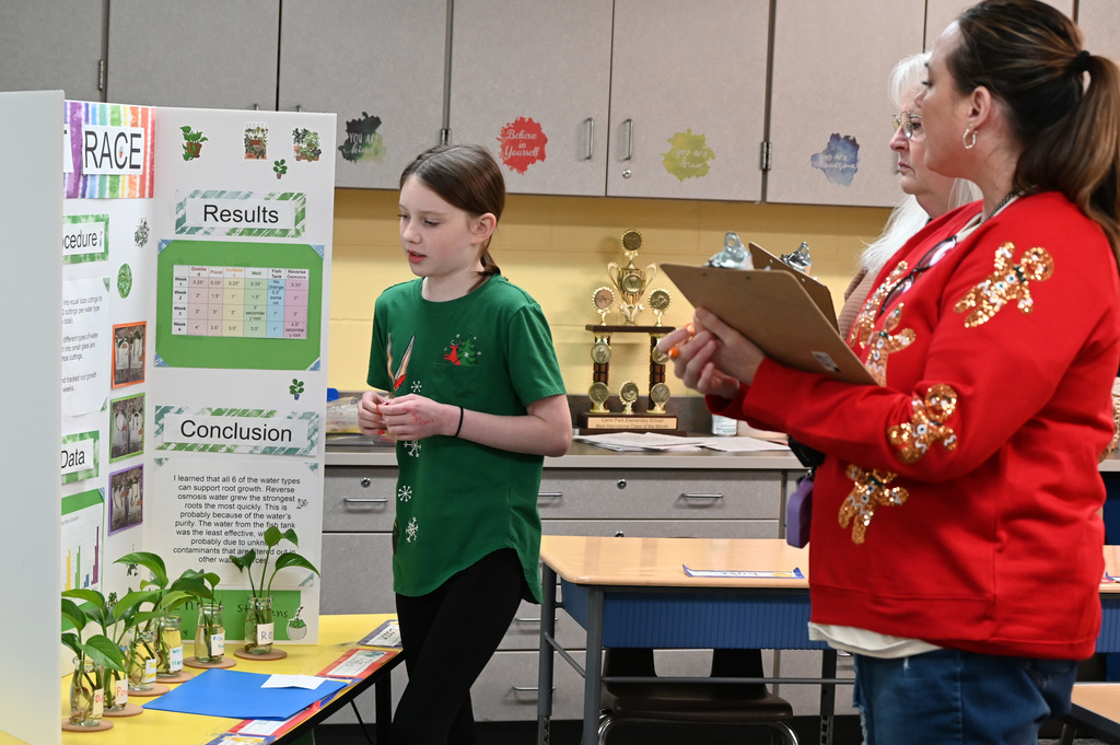 student with 2 judges presenting science fair project