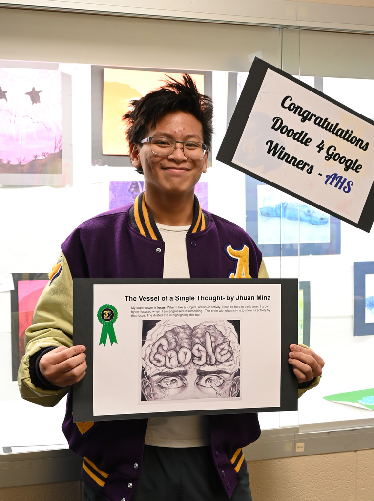 student holding poster of his artwork