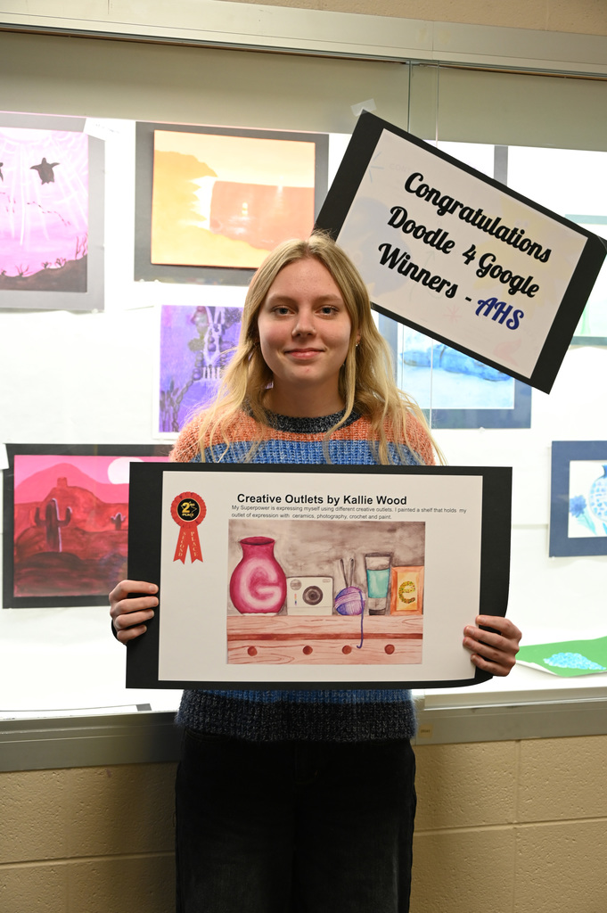 Student holding a poster of her artwork