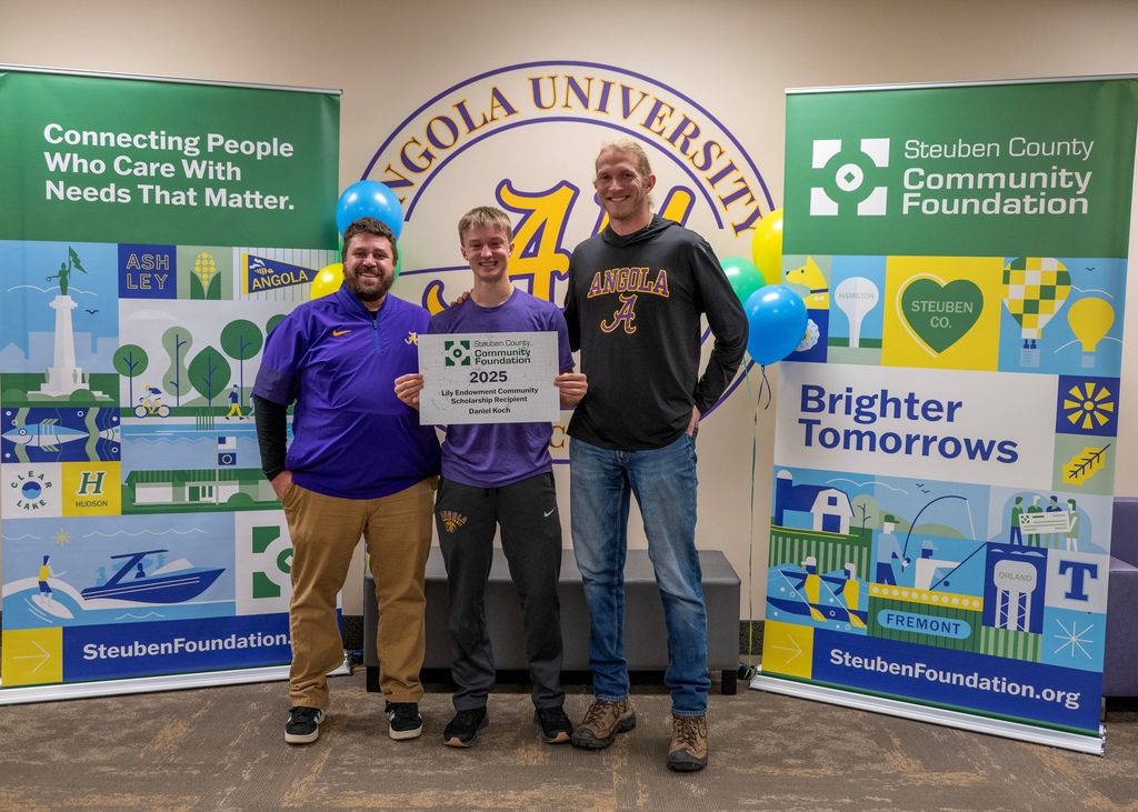 three people standing in a ling middle person holding a sign