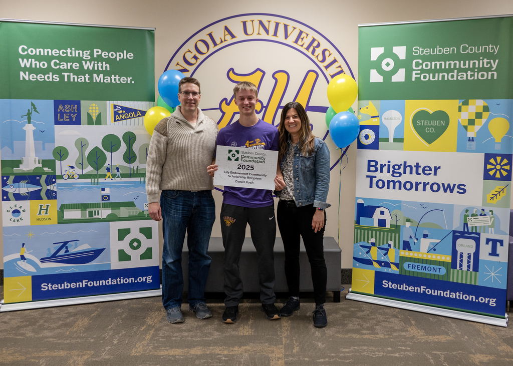 three people standing in a ling middle person holding a sign