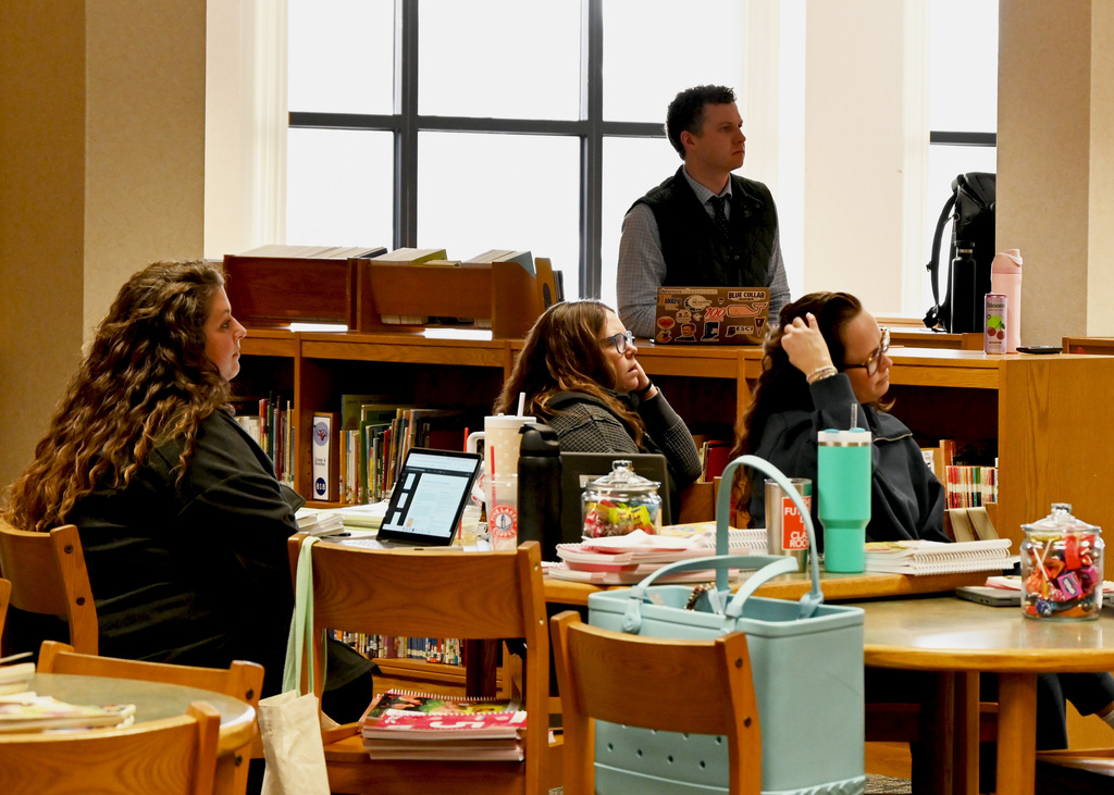 People sitting around tables, listening