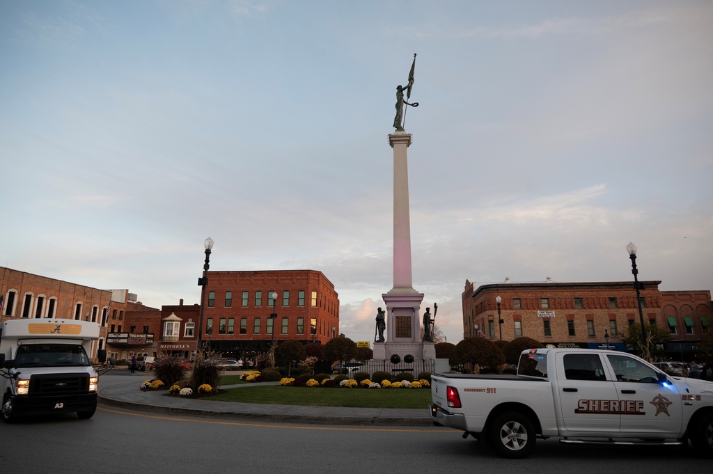 Sherrif truck and angola high school bus going around mound