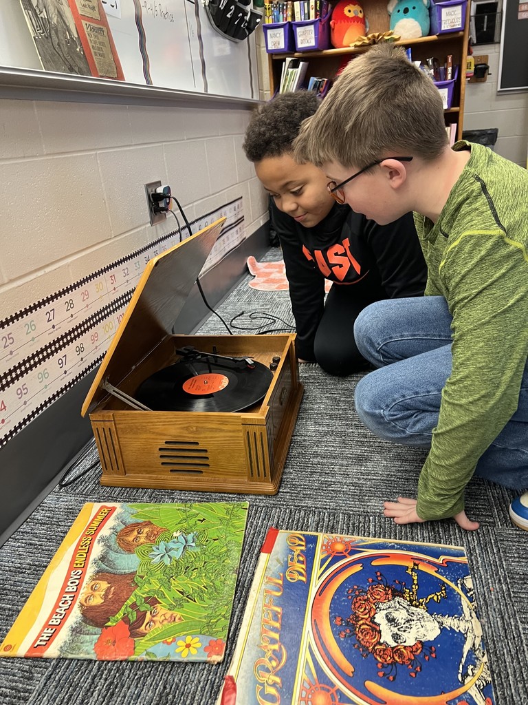 stwo boys looking at a record player