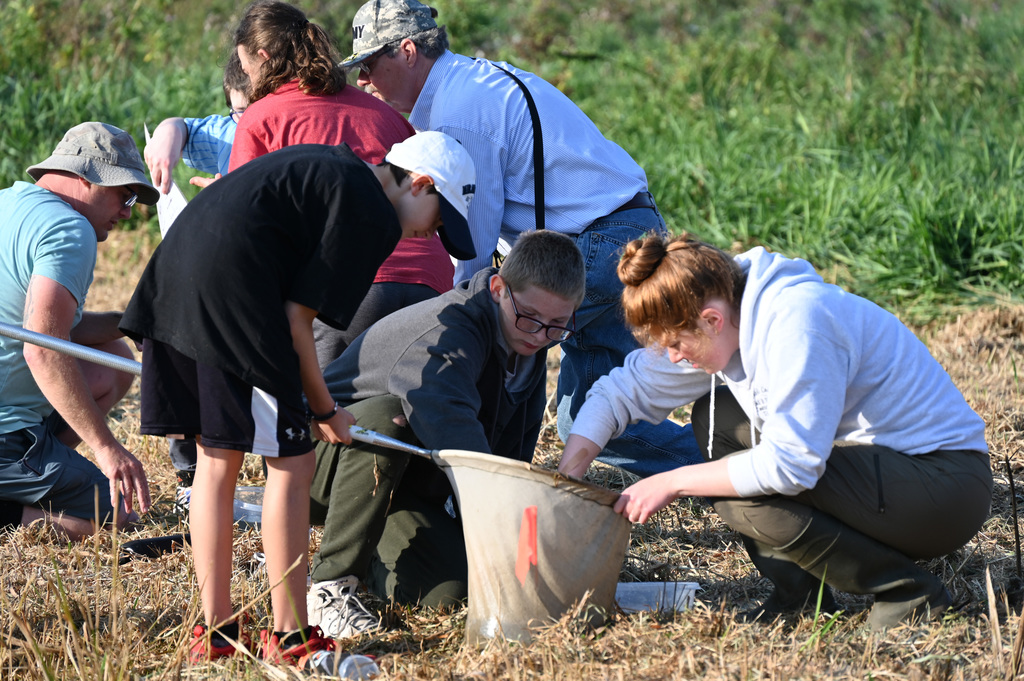 people looking and pulling items out of a net