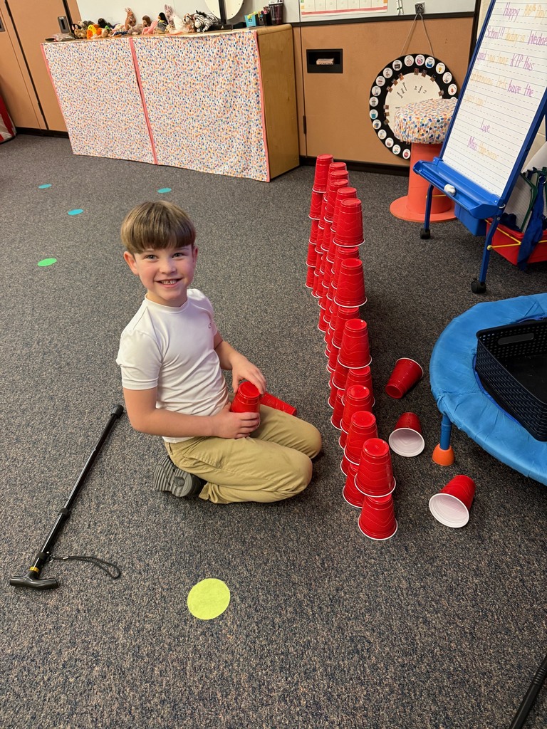 boy making towers of red cups