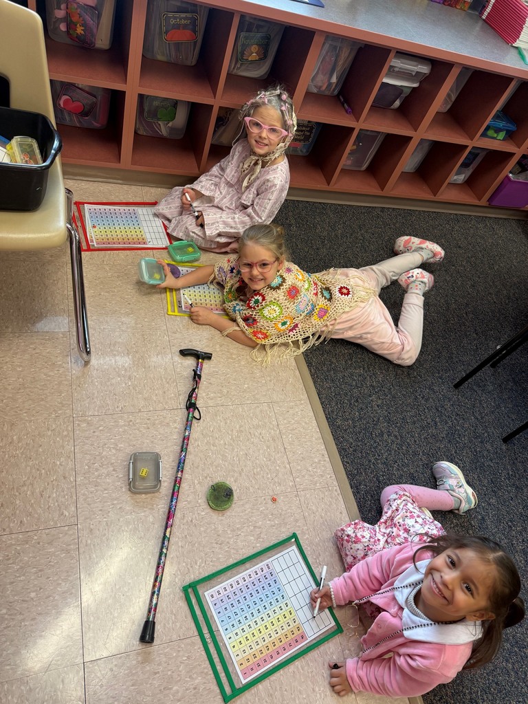 3 girls working on math projects while sitting on floor