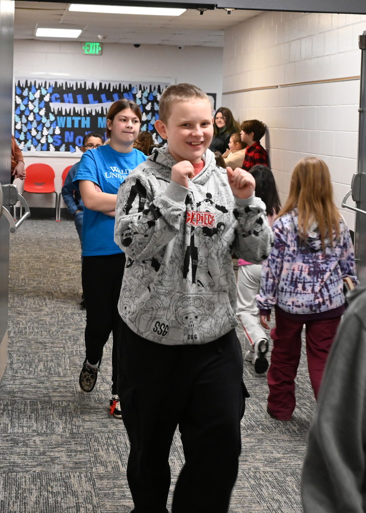 boy smiling while walking down hall