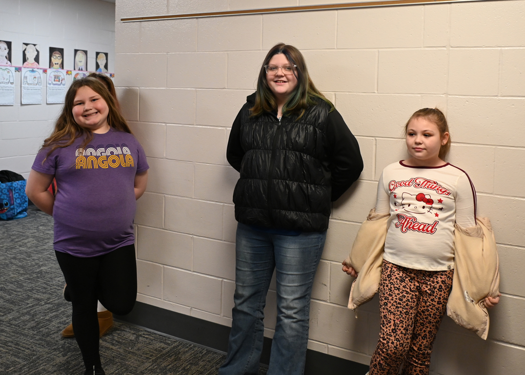 3 girls leaning on wall smiling