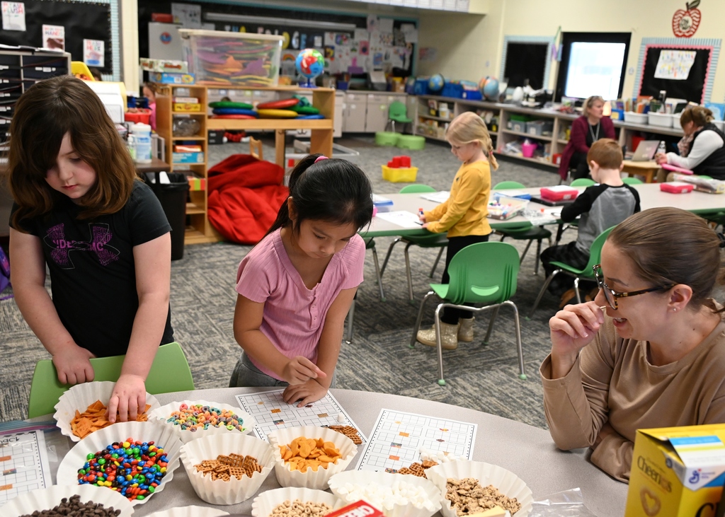 two students and a teacher working at table
