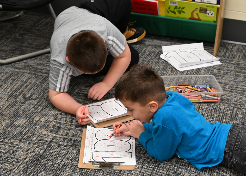 two boys on floor coloring