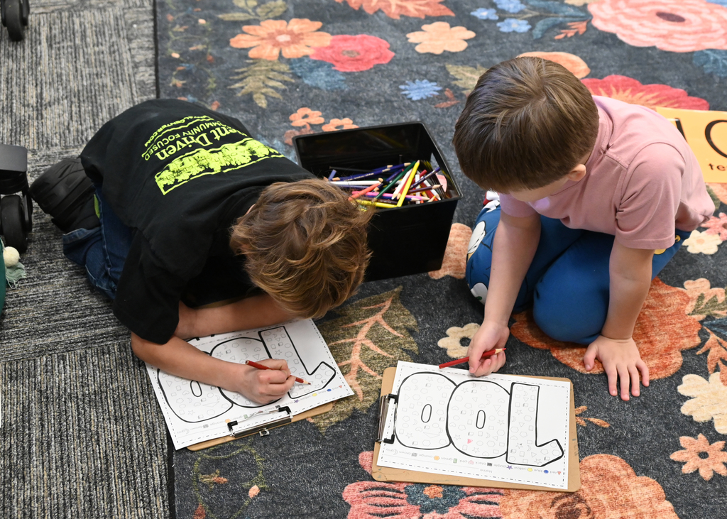 two boys coloring on floor