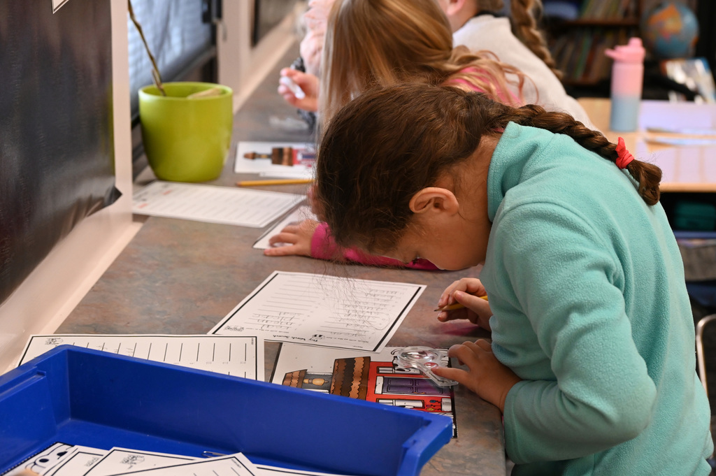 girl looking through small magnifying glass