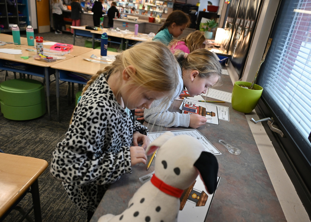 4 girls working on counter with stuffed dalmation looking on