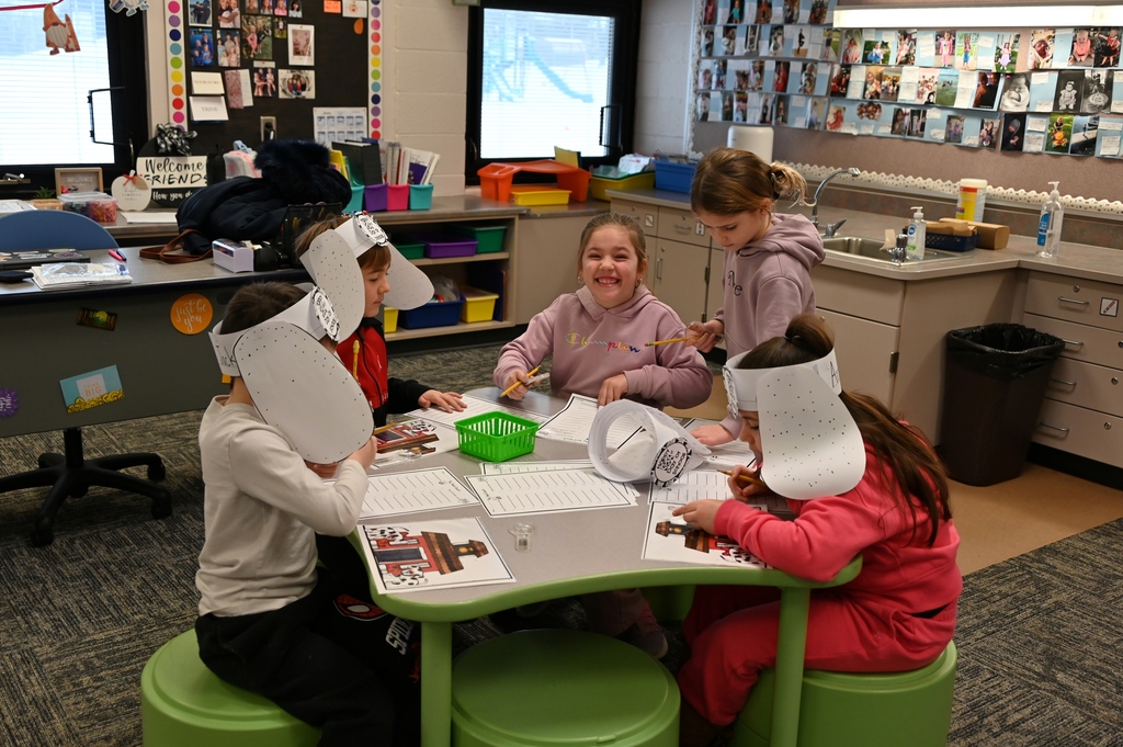 5 kids at table working on papers
